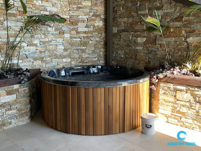 myHotTub with a natural stone wall backdrop thanks to the team @ Paramount Pools Auckland